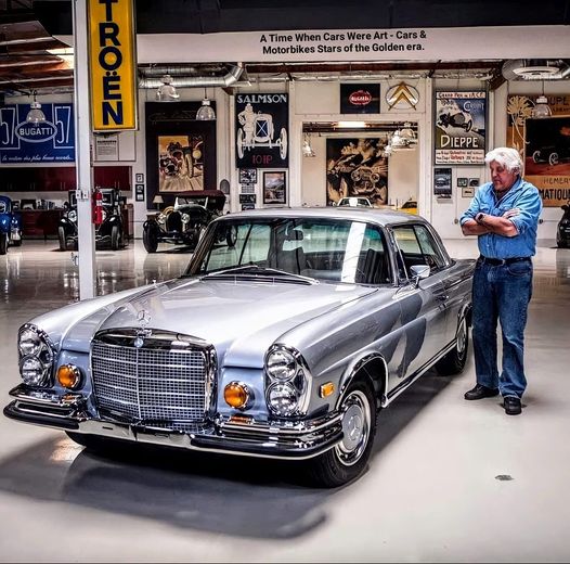 American comedian and talk show host Jay Leno posing with his Beloved 1971 Mercedes-Benz 280SE Coupé 3.5 V8.at Jay Leno’s Garage.