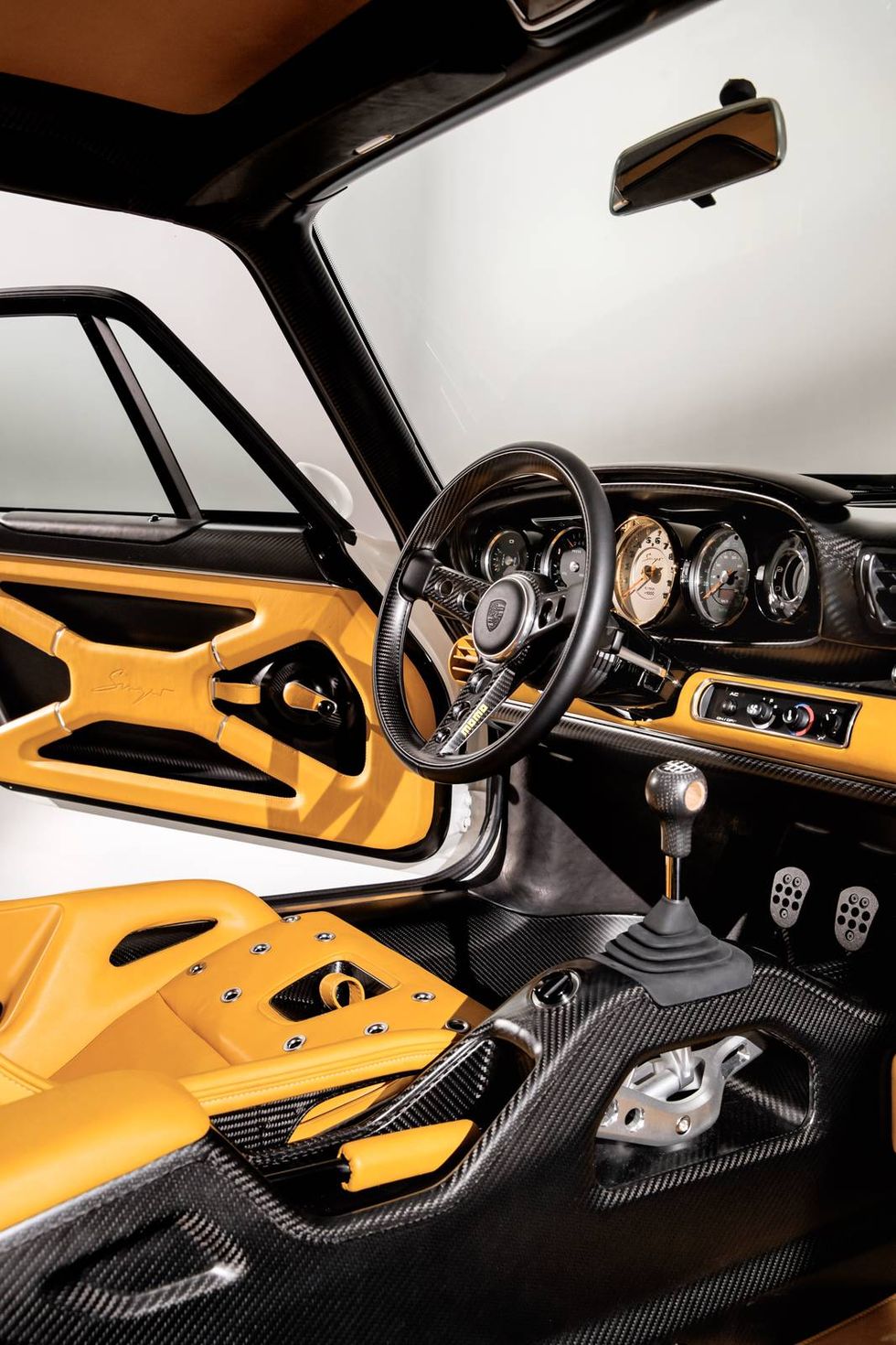 The 1990 Porsche 911 “reimagined by Singer” has a parallax white exterior and a Norfolk yellow interior.